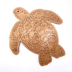 Photo of a puzzle cut out of wood in the shape of a sea turtle.